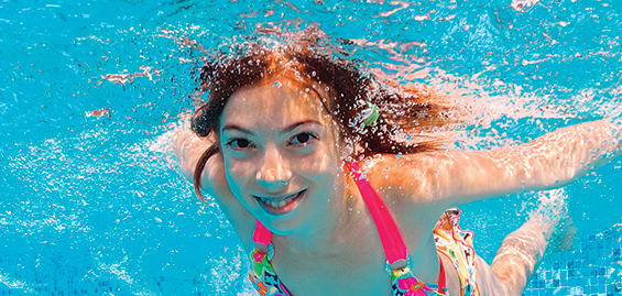 Beautiful girl swims undewater in pool