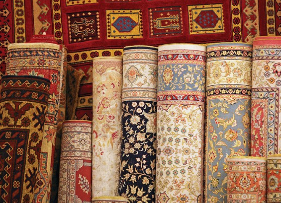 Carpet store with stacks of woven Turkish and Persian rugs